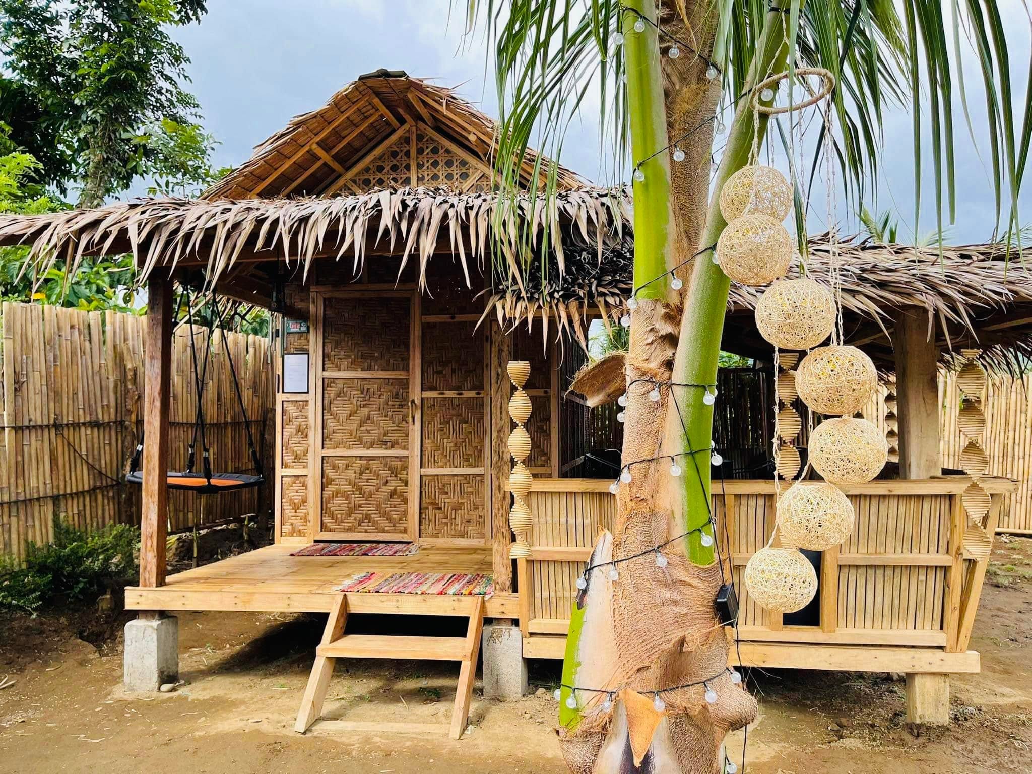 Wooden steps up to a raised bamboo cabin